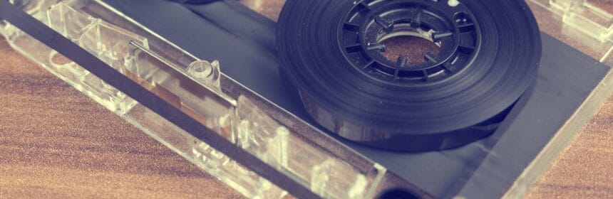 Clear and Black Cassette Tape on Brown Wooden Surface