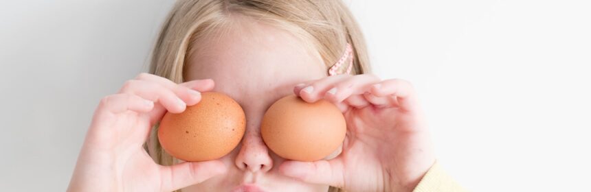 girl holding two eggs while putting it on her eyes