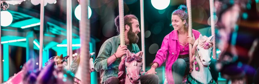 man and woman riding a carousel